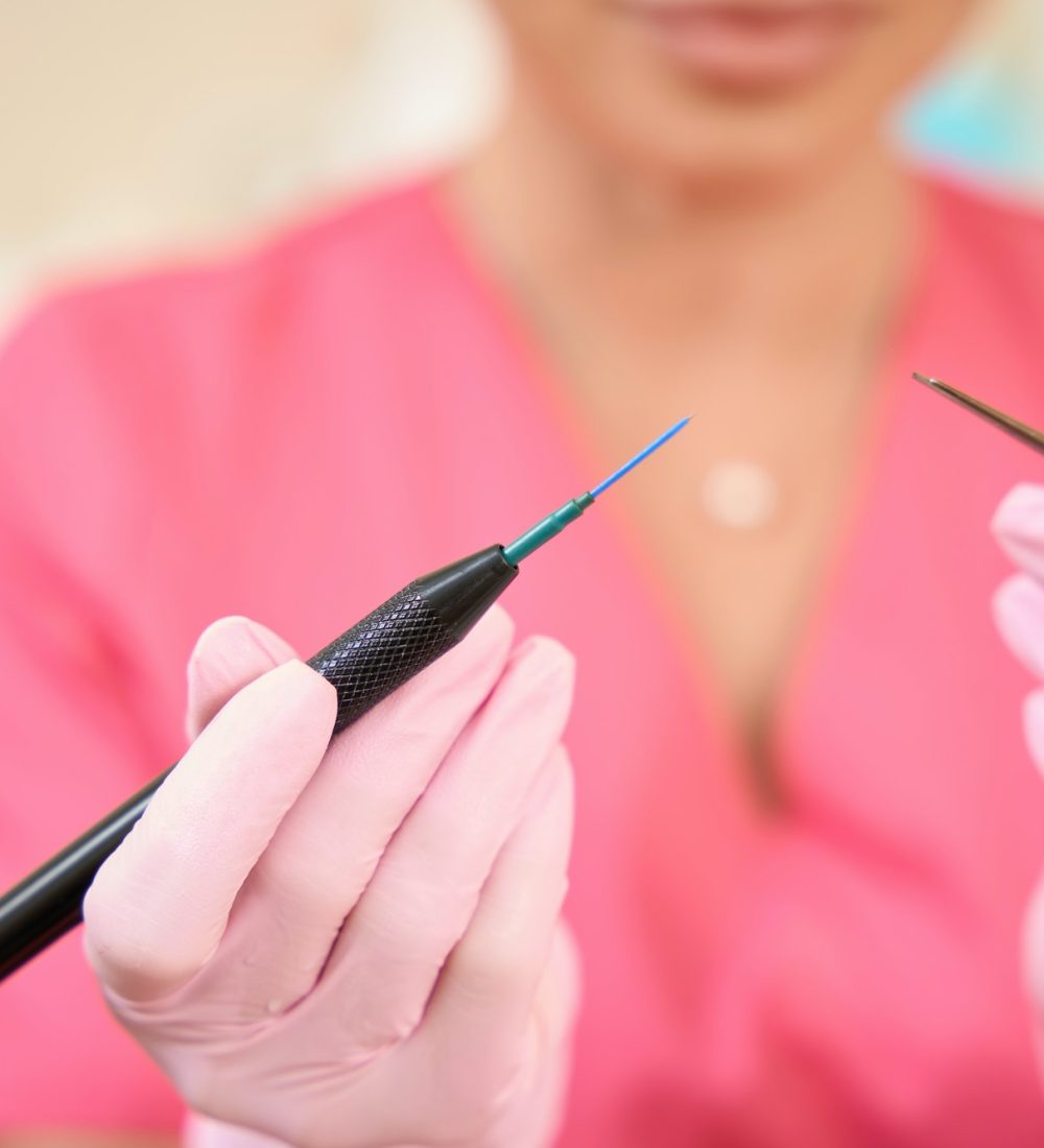Woman beautician holds radio wave scalpel in her hands